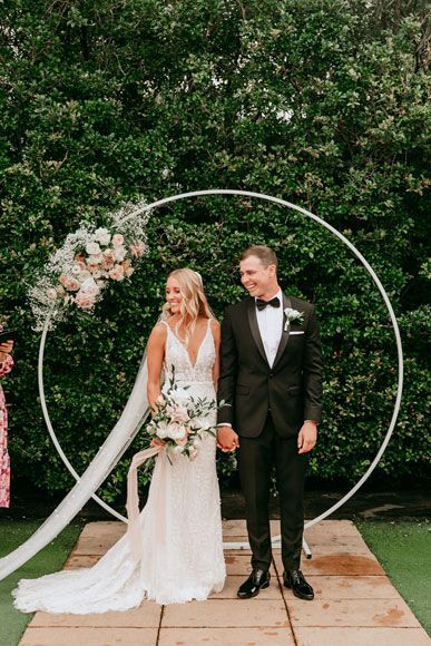 A bride and groom are posing for a picture at their wedding ceremony.