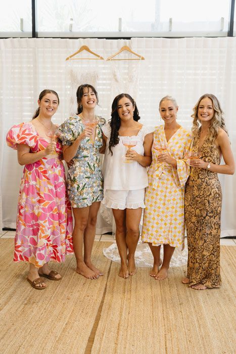 A group of women standing next to each other holding champagne glasses.