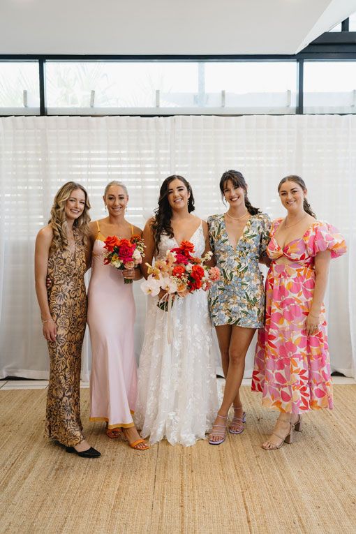 A bride and her bridesmaids are posing for a picture together.