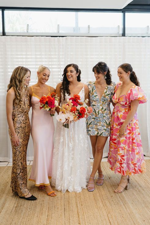 A bride and her bridesmaids are posing for a picture together.