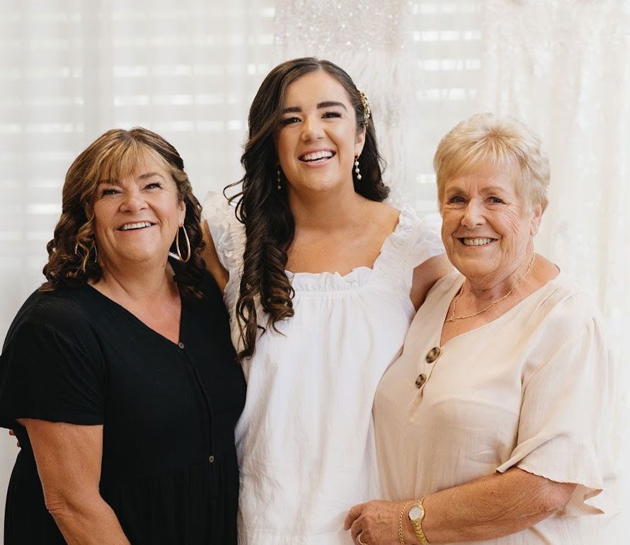 Three women are posing for a picture together and smiling.