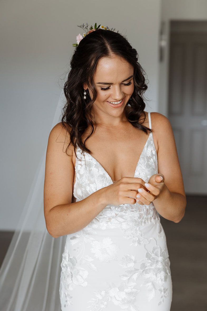 A woman in a wedding dress is looking at her phone.