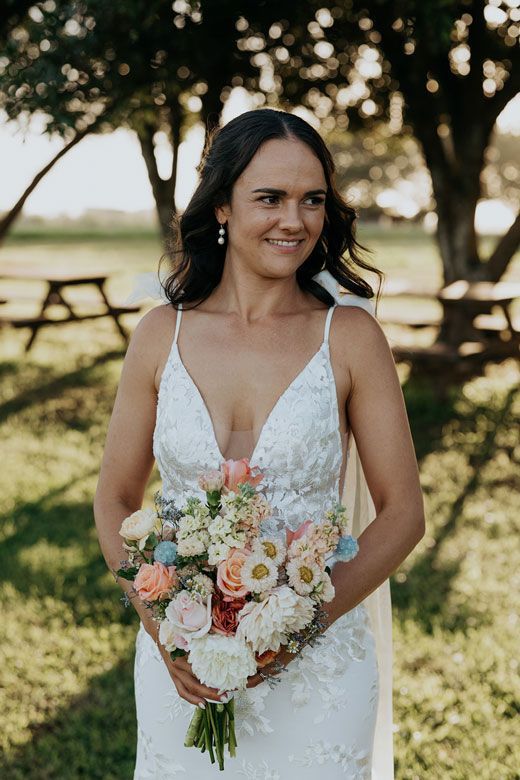 The bride is wearing a white dress and holding a bouquet of flowers.
