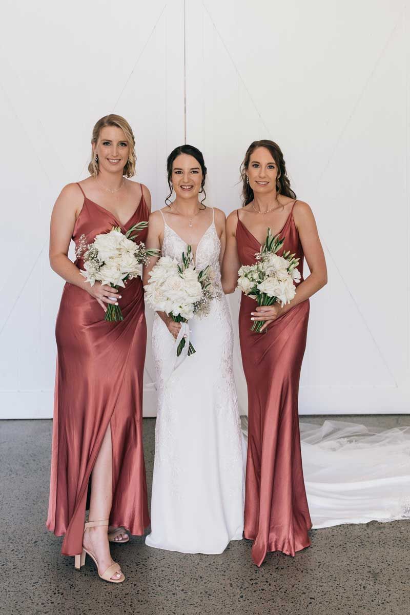 A bride and her bridesmaids are posing for a picture.