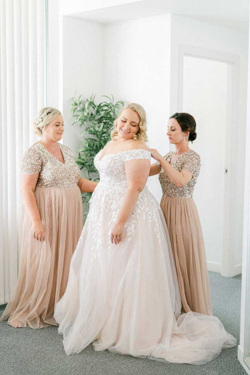 A bride is getting ready for her wedding with her bridesmaids.