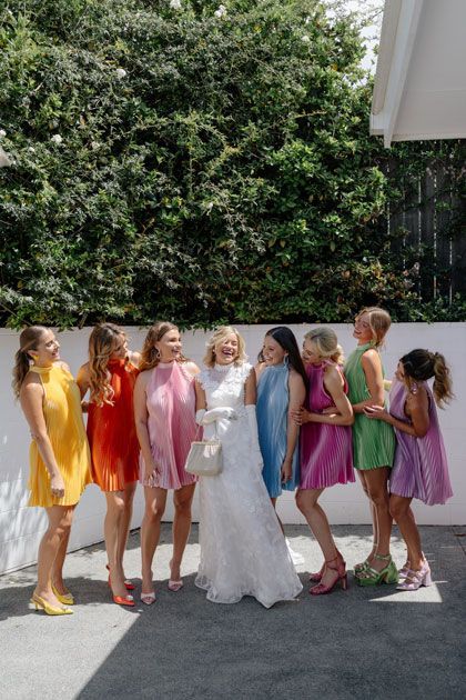 A bride and her bridesmaids are posing for a picture together.