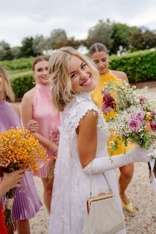 A woman in a white dress is holding a bouquet of flowers.