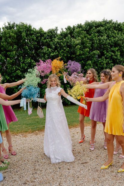 A bride and her bridesmaids are standing in a circle holding bouquets of flowers.