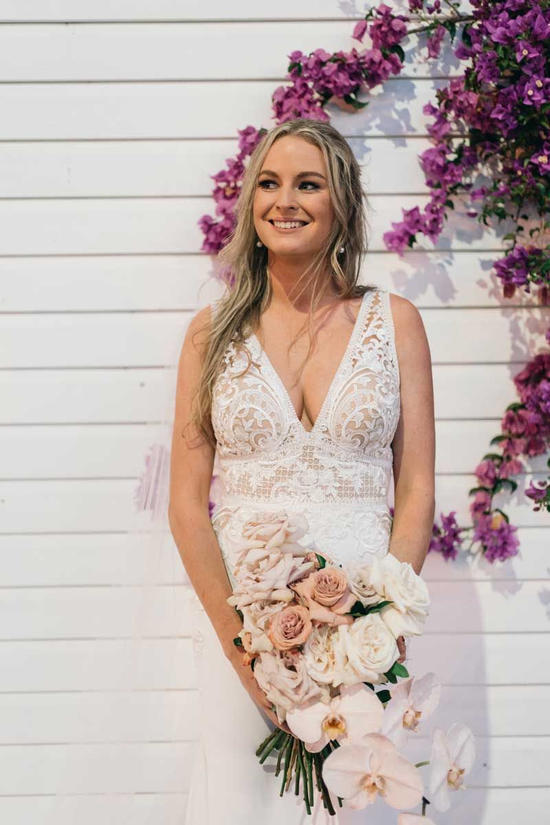 The bride is wearing a white dress and holding a bouquet of flowers.