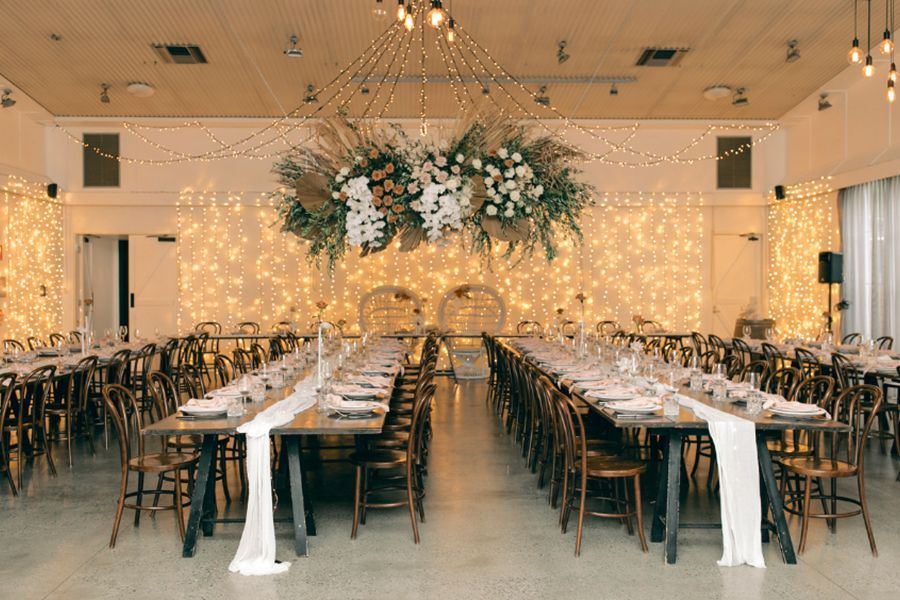 A large room with tables and chairs set up for a wedding reception.