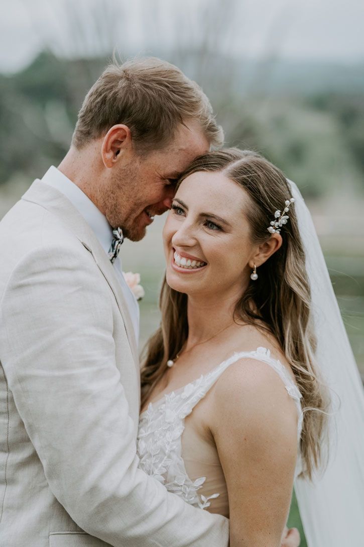 A bride and groom are posing for a picture on their wedding day.