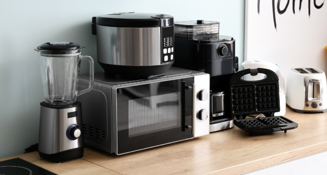 A kitchen counter with a microwave , blender , coffee maker , toaster and other appliances.