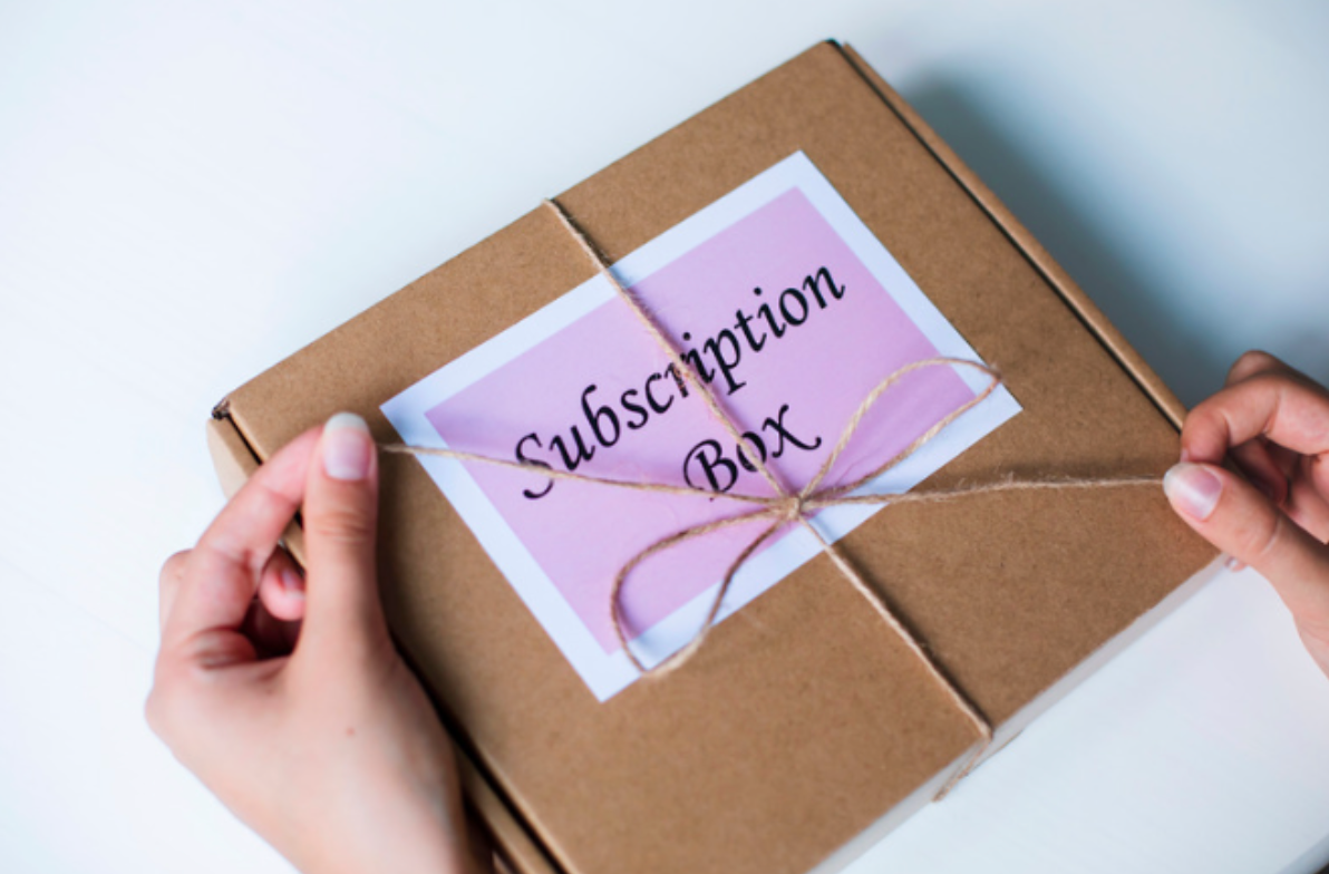 A person is holding a box that says subscription box on it