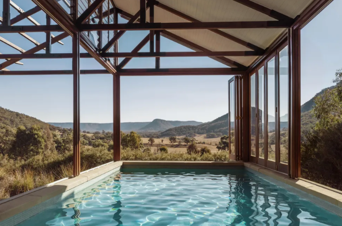 A large indoor swimming pool with a view of the mountains.