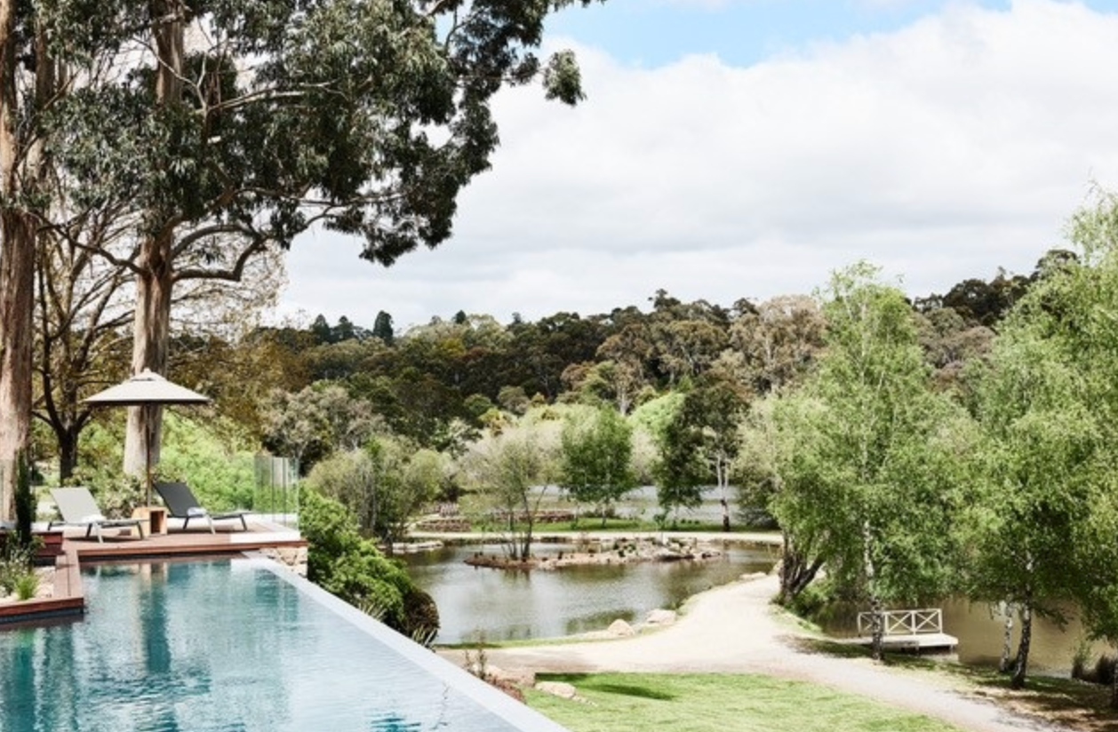 A swimming pool with a view of a lake and trees