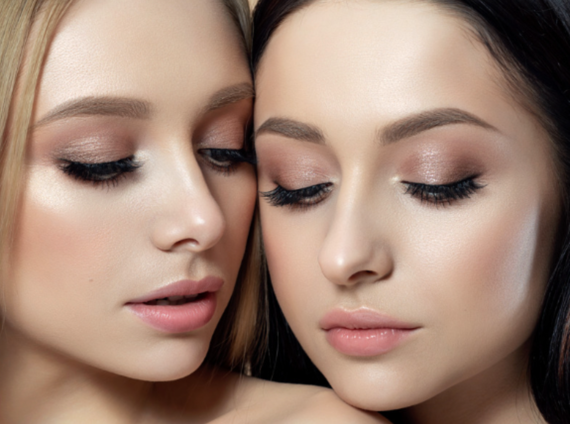 A close up of two women 's faces with their eyes closed.