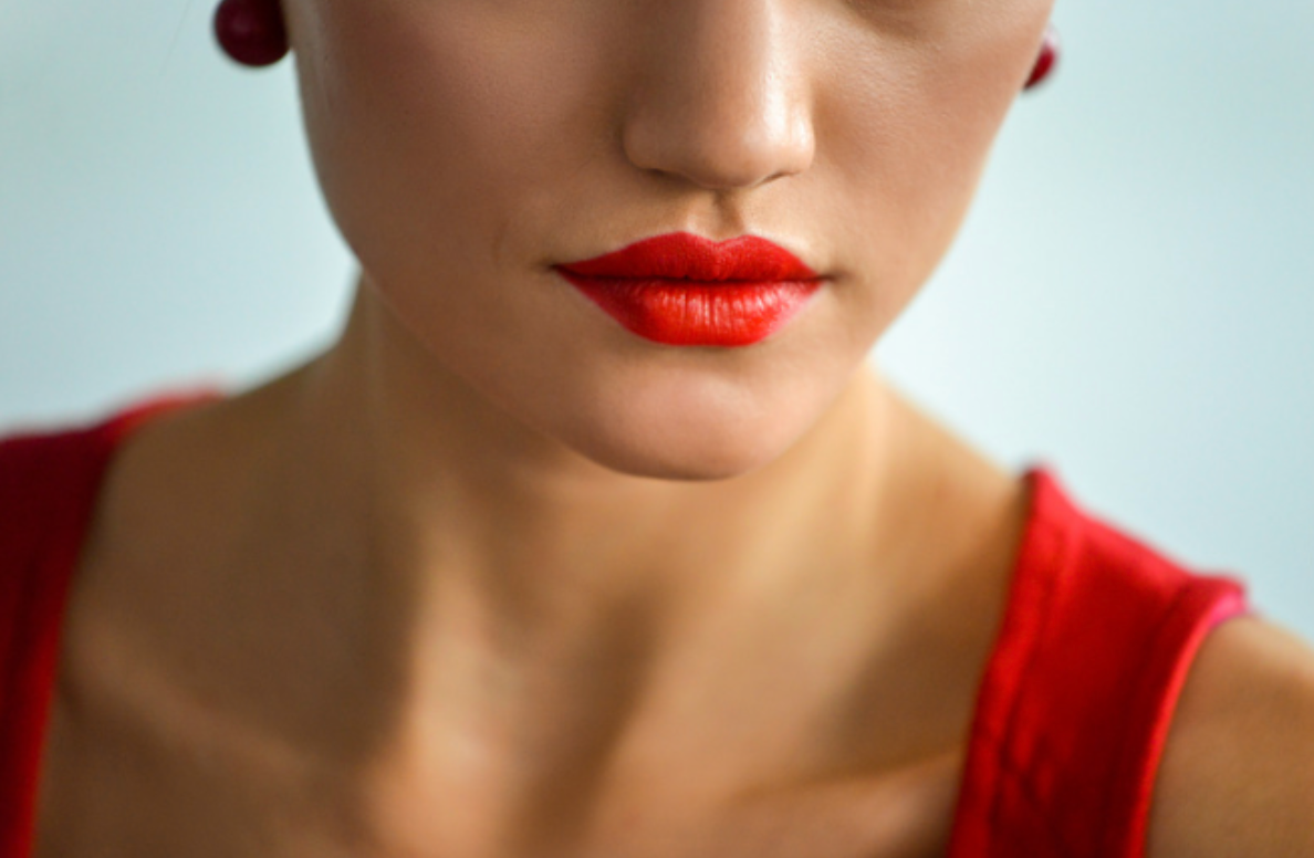 A close up of a woman 's face with red lipstick.