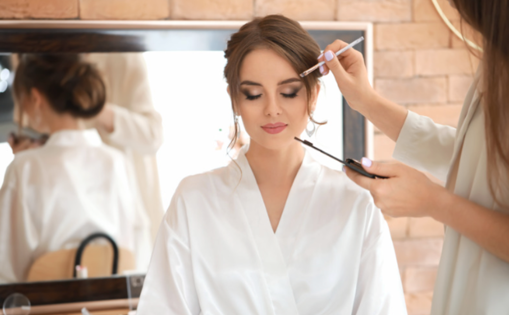 A woman is getting her hair done by a hairdresser in front of a mirror.