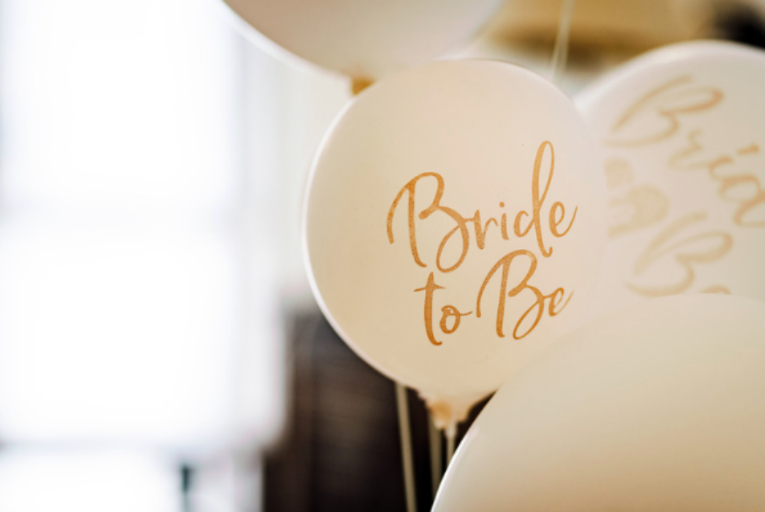 A bunch of white balloons with the words `` bride to be '' written on them.