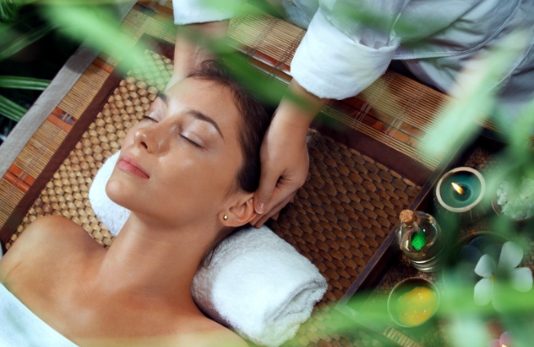 A woman is getting a head massage at a spa.