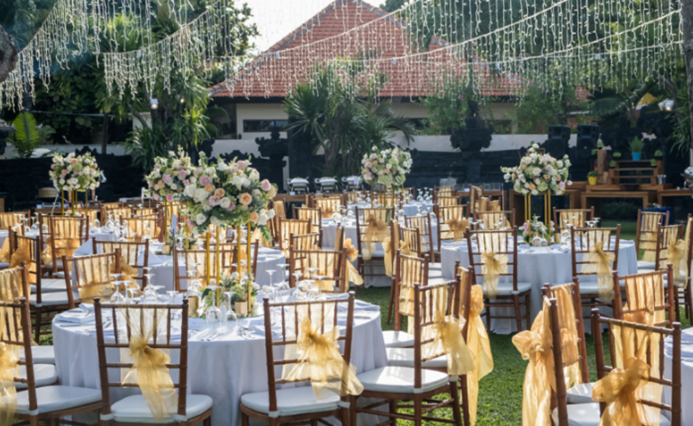 A row of tables and chairs set up for a wedding reception.