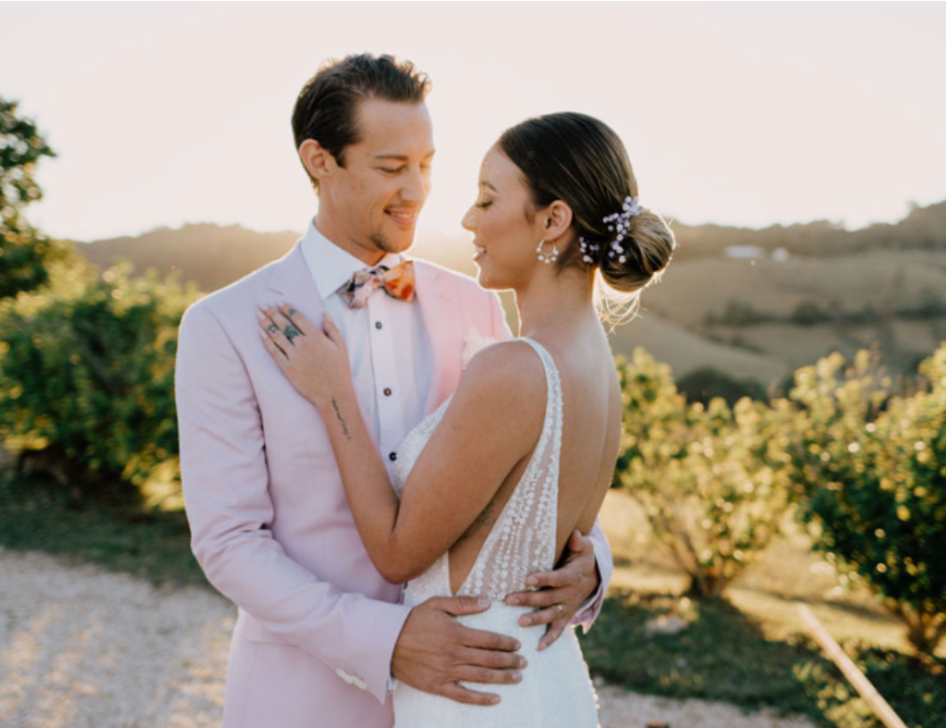 A bride and groom are posing for a picture on their wedding day.