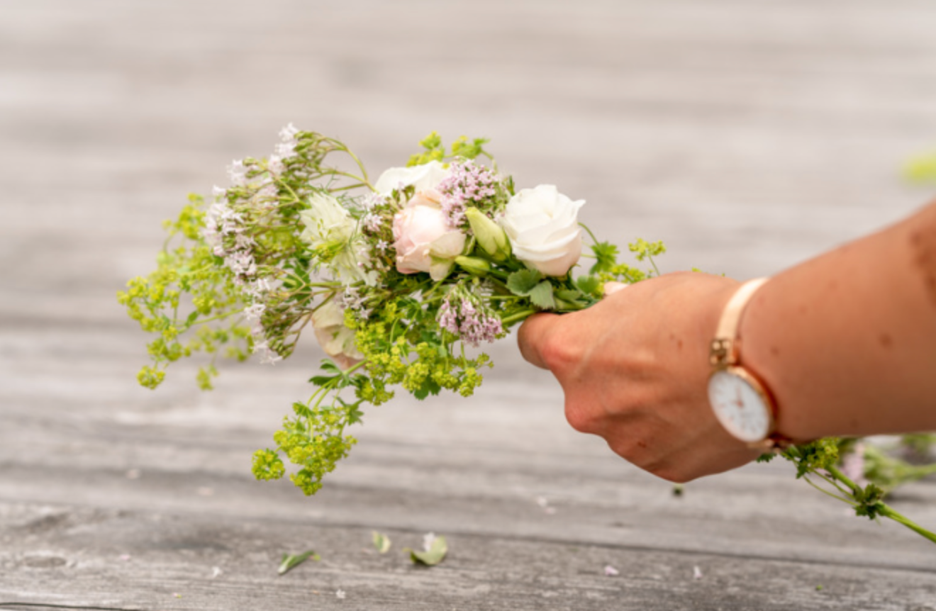 A woman is holding a bouquet of flowers in her hands.