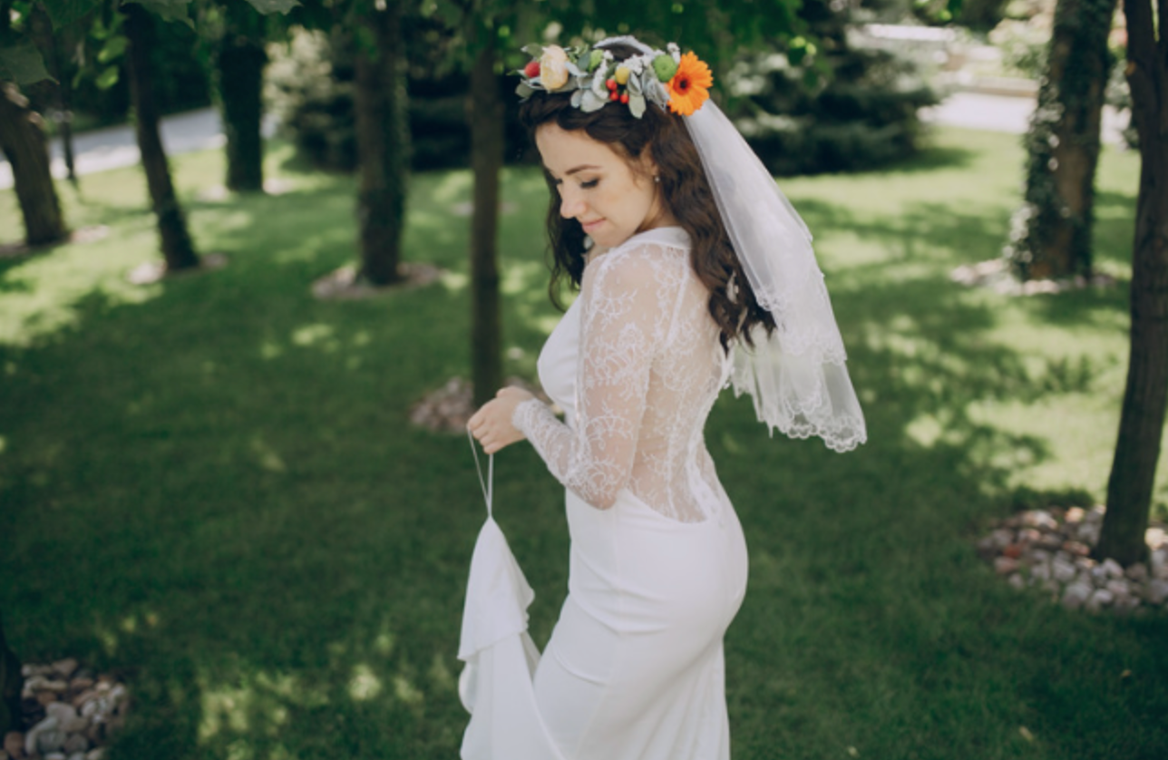 The bride is wearing a veil and a flower crown on her head.