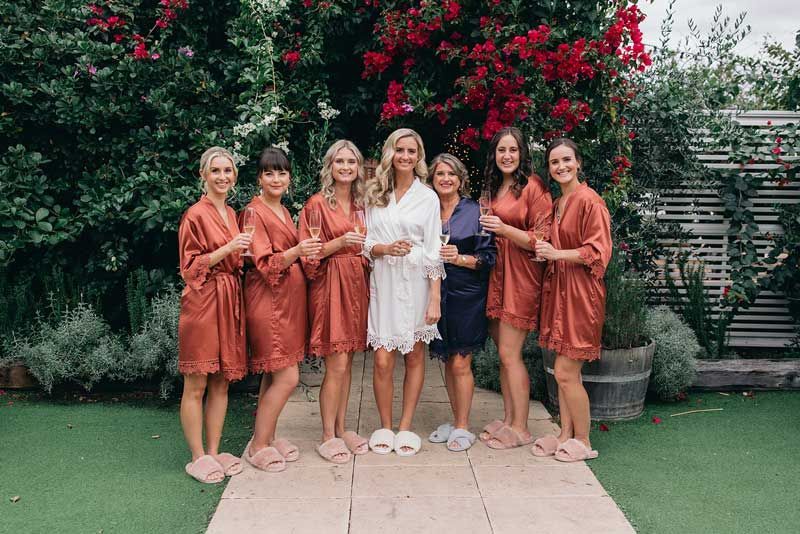 A bride and her bridesmaids are posing for a picture.