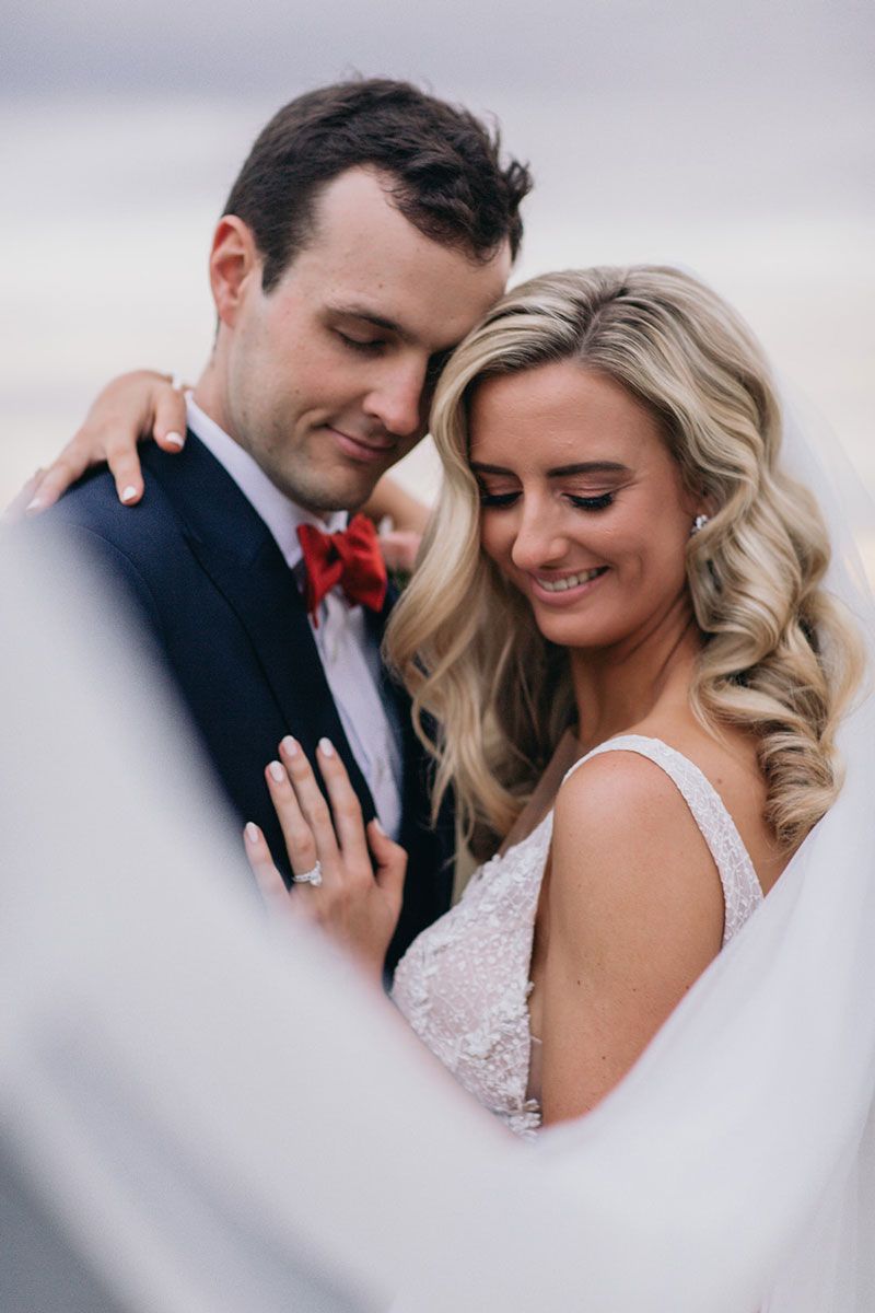 A bride and groom are posing for a picture on their wedding day.