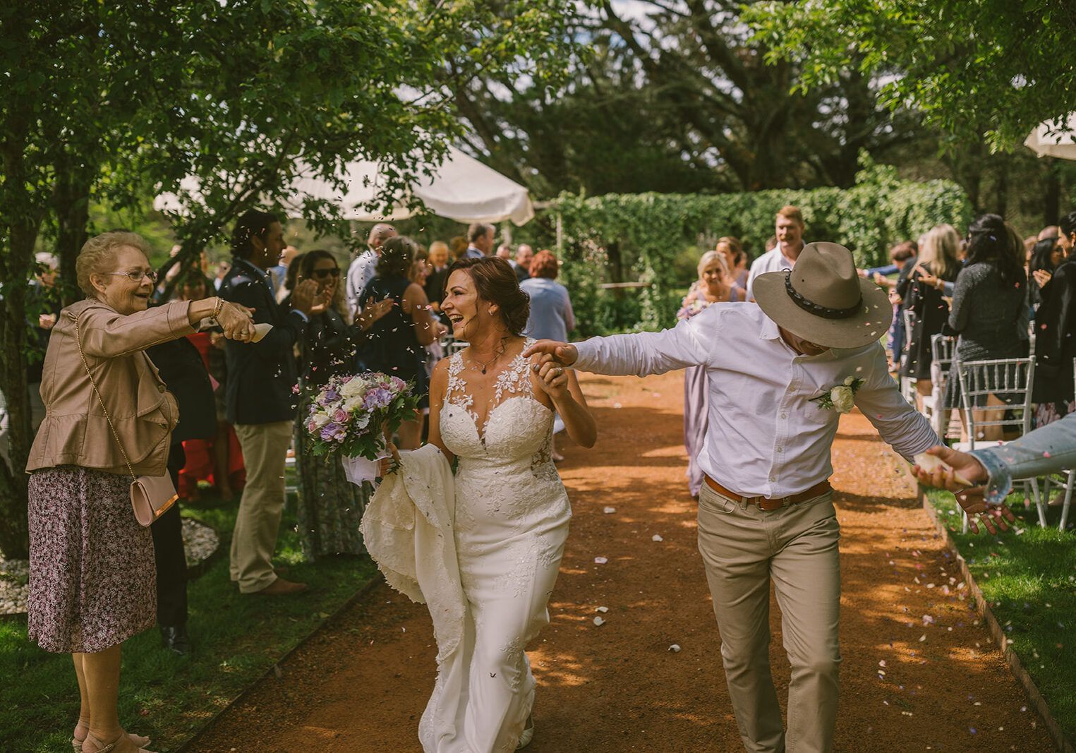 A bride and groom are walking down the aisle at their wedding.