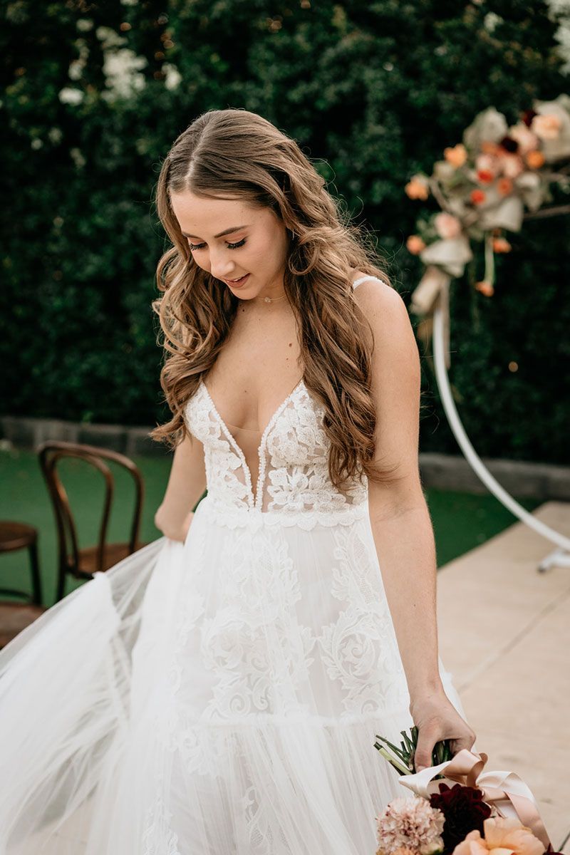 A woman in a wedding dress is holding a bouquet of flowers.