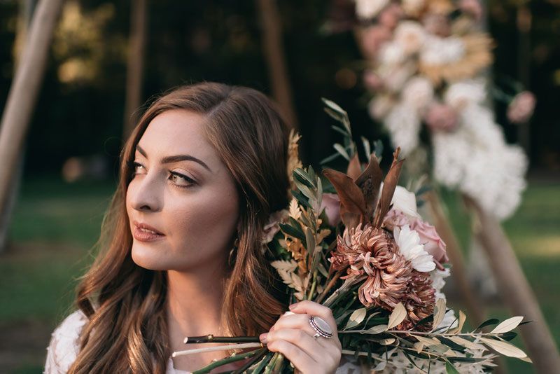 A woman is holding a bouquet of flowers in her hand.