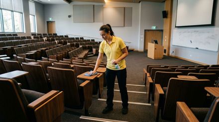 Cleaner wiping and sanitizing lecture hall desks and seating surfaces Minnetonka, MN