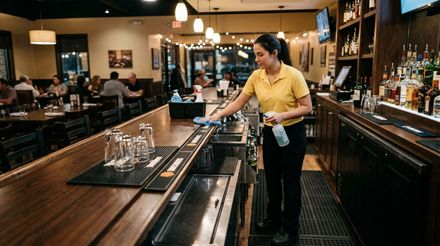 Cleaner wiping and sanitizing restaurant bar top and glassware area Minnetonka, MN