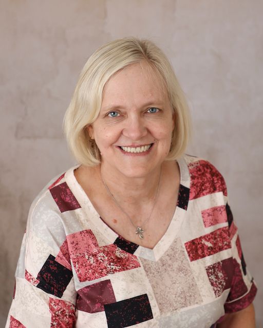 A woman in a leopard print shirt is smiling for the camera.