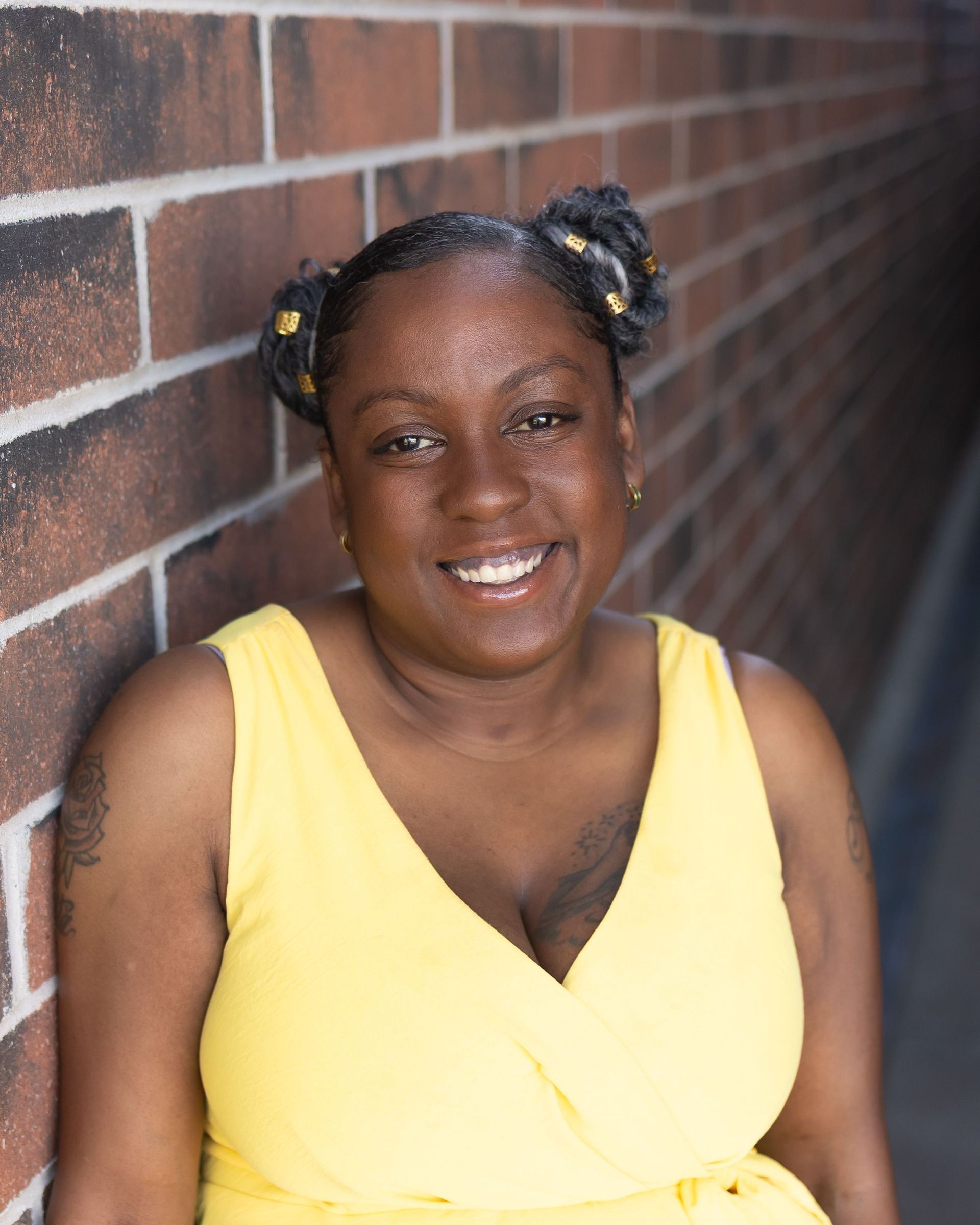 A woman wearing glasses and a necklace is smiling for the camera.
