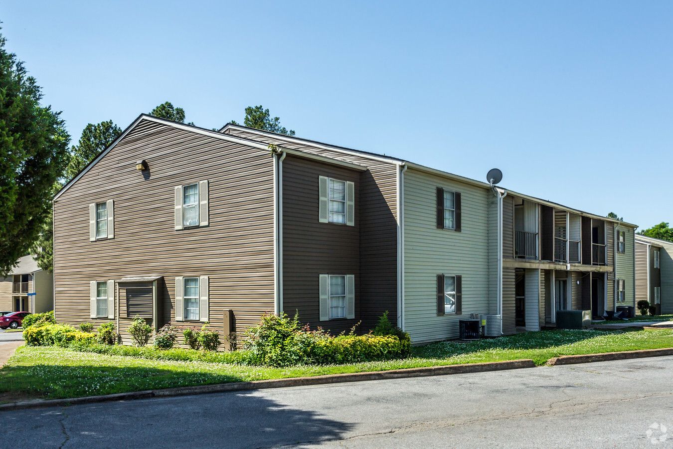 A large apartment building with a lot of windows on a sunny day.