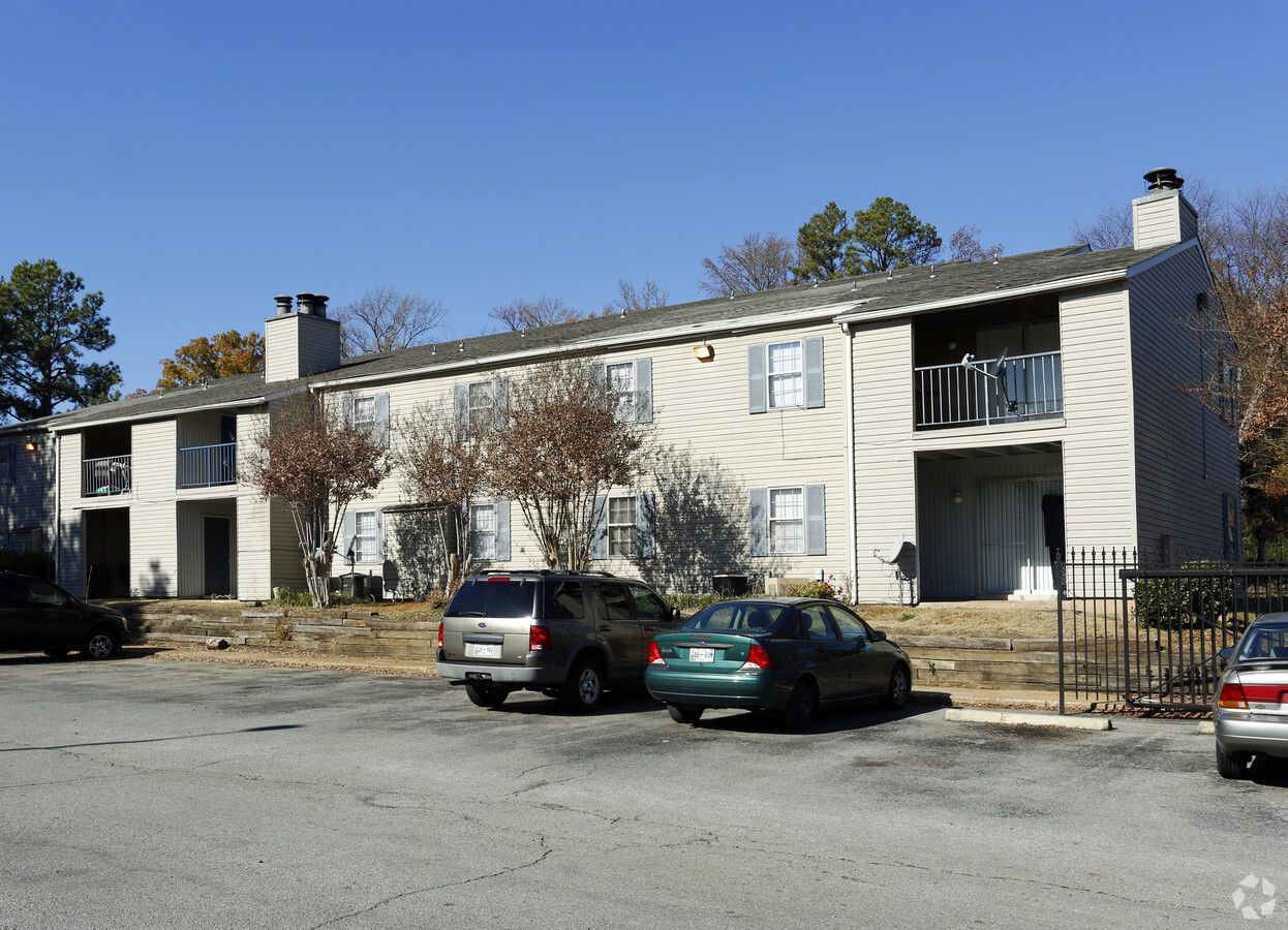 A white apartment building with cars parked in front of it