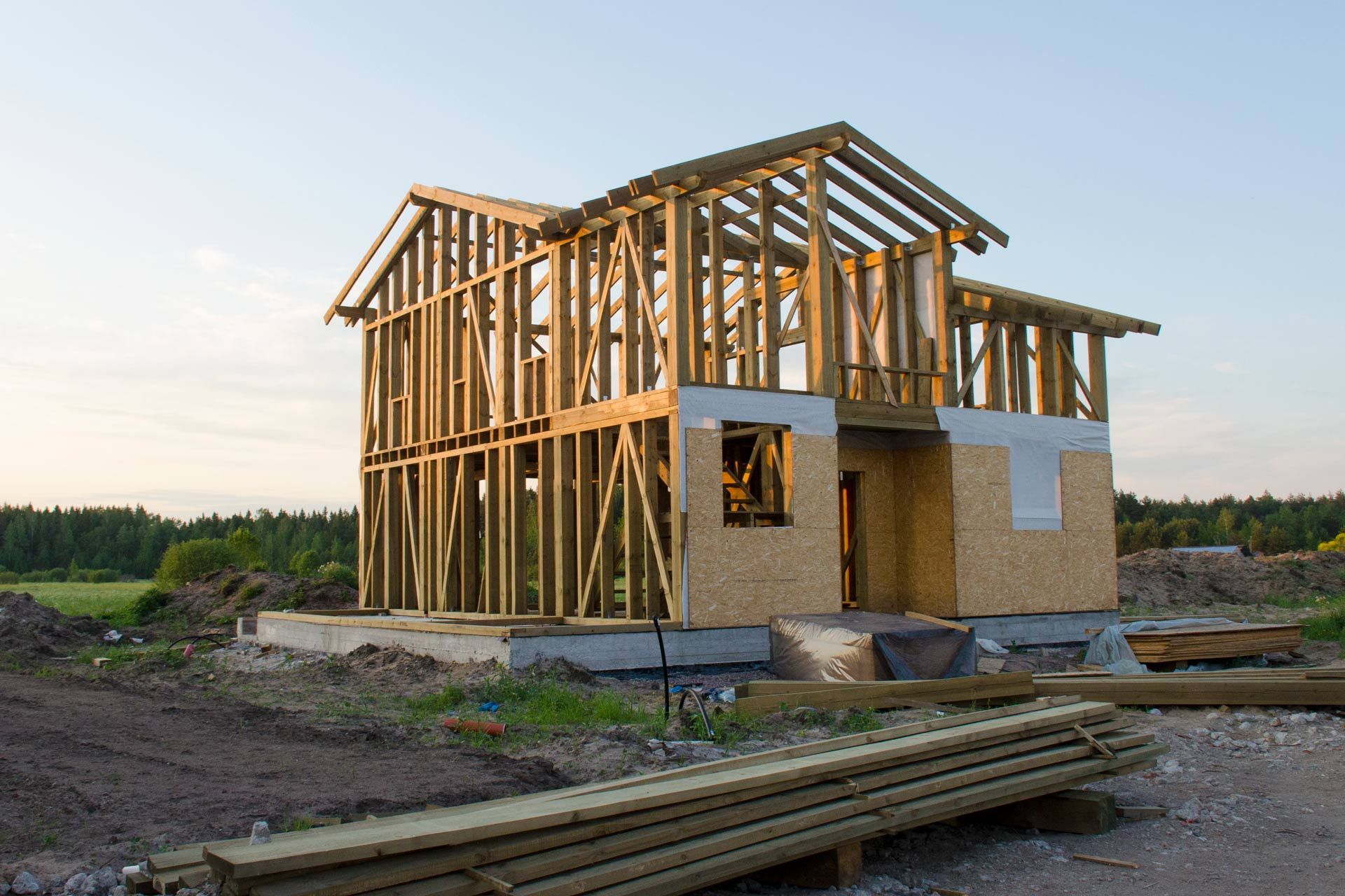 A wooden house is being built in a rural area