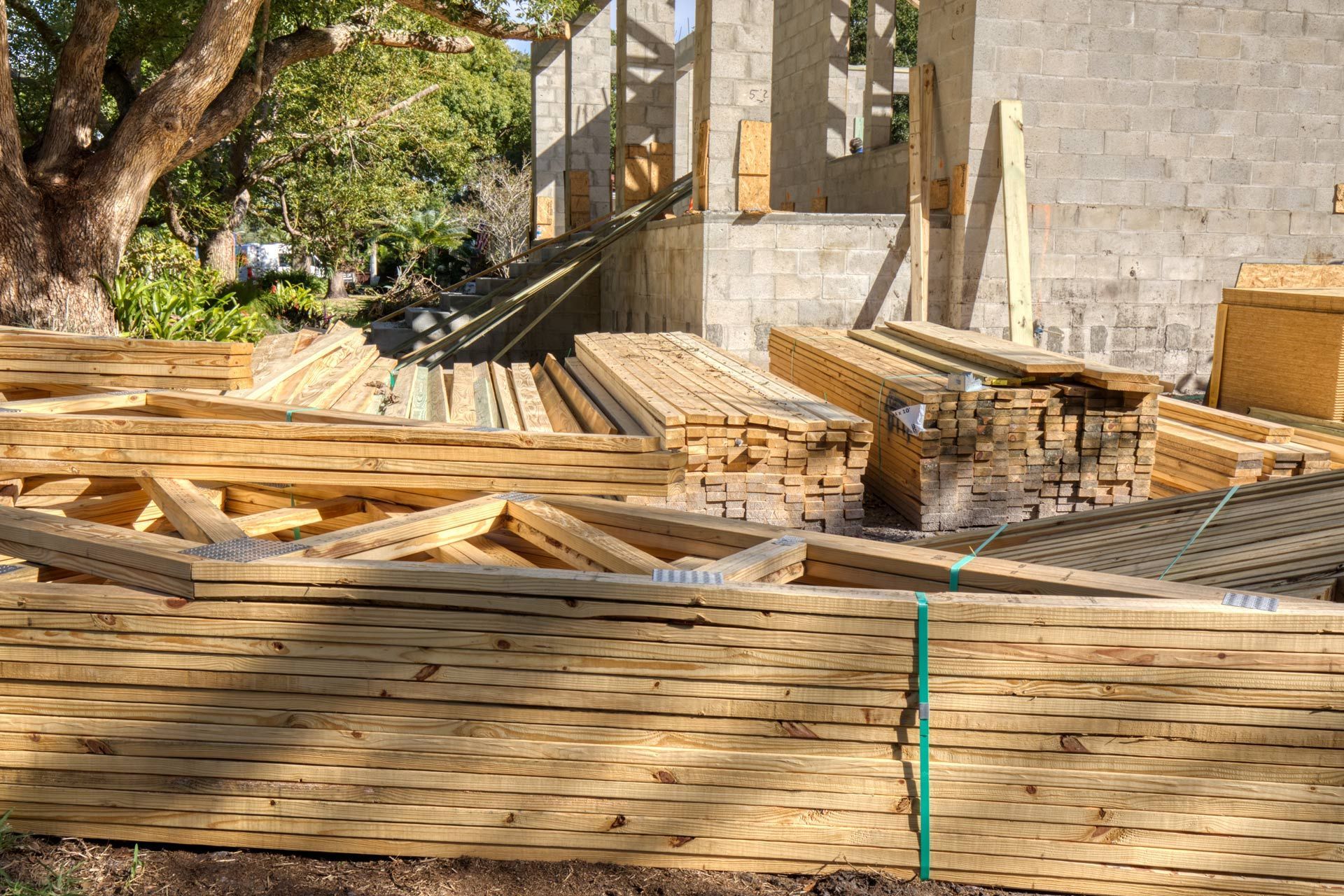 A pile of wood is sitting in front of a building under construction