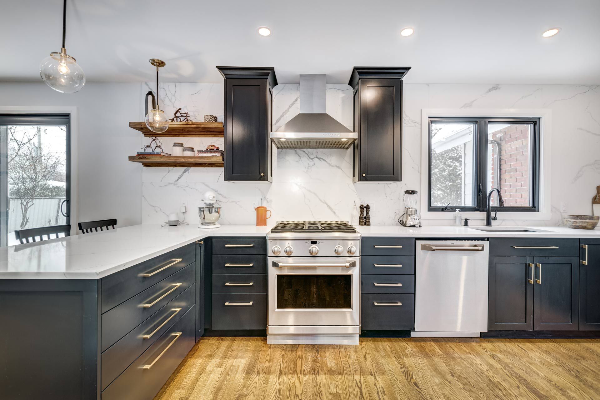 A kitchen with black cabinets and stainless steel appliances