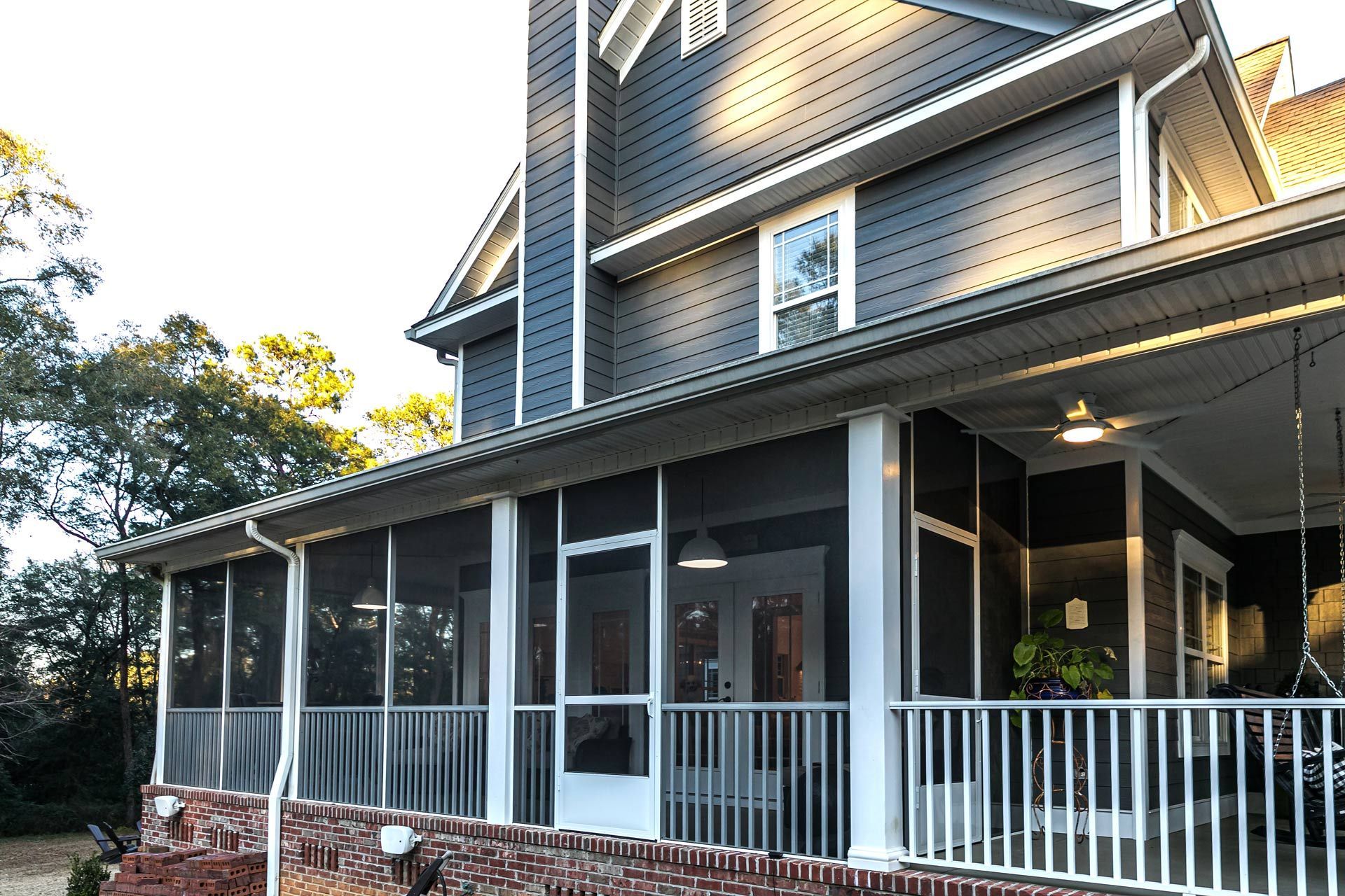 A large house with a screened in porch and a ceiling fan