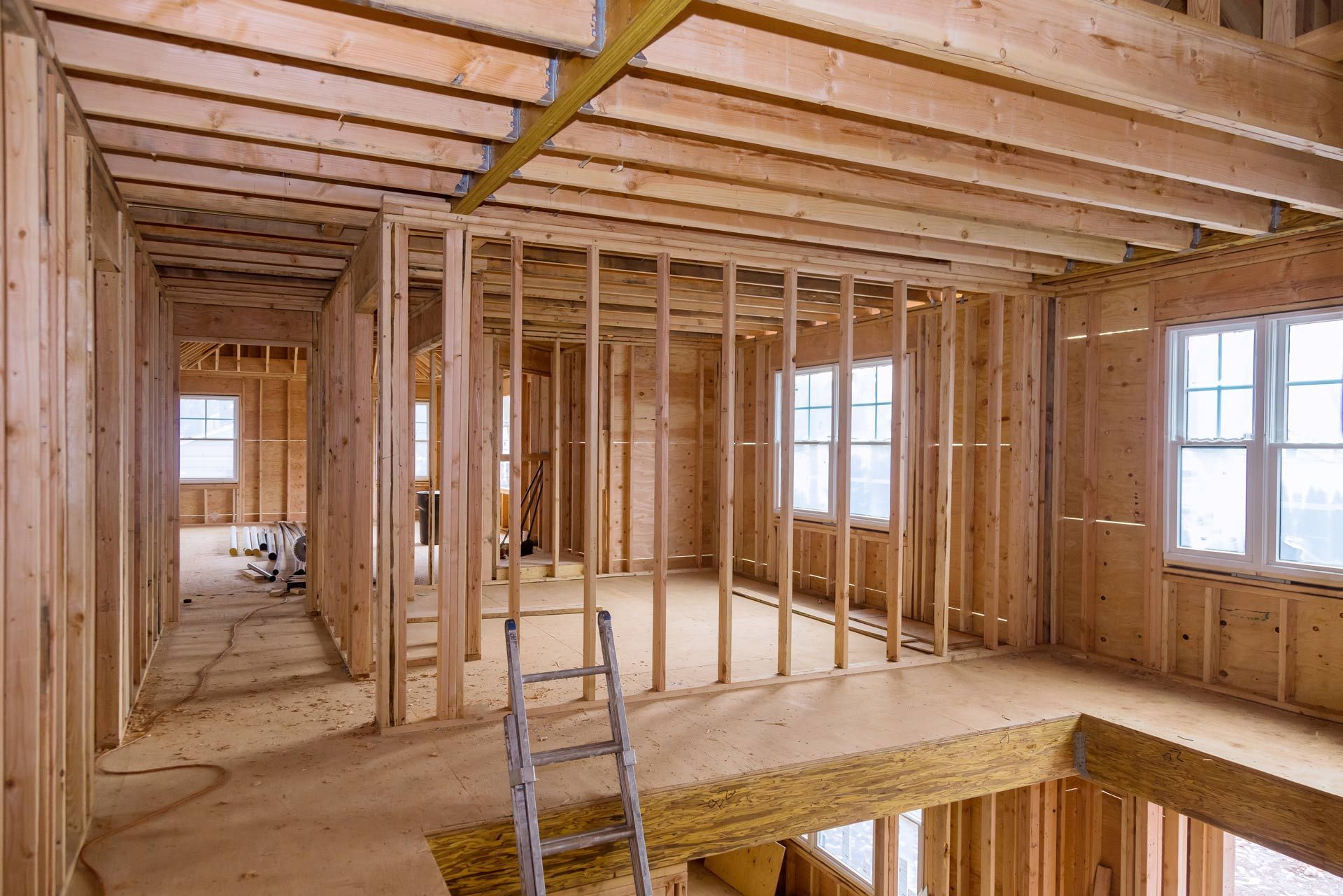 The inside of a house under construction with a ladder in the middle of the room