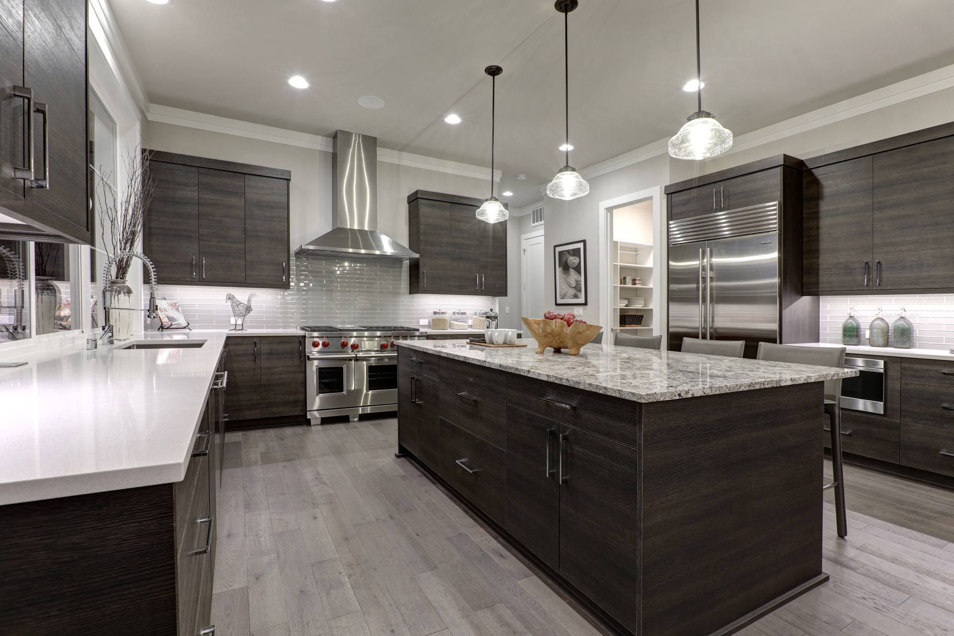 A large kitchen with a large island in the middle and stainless steel appliances