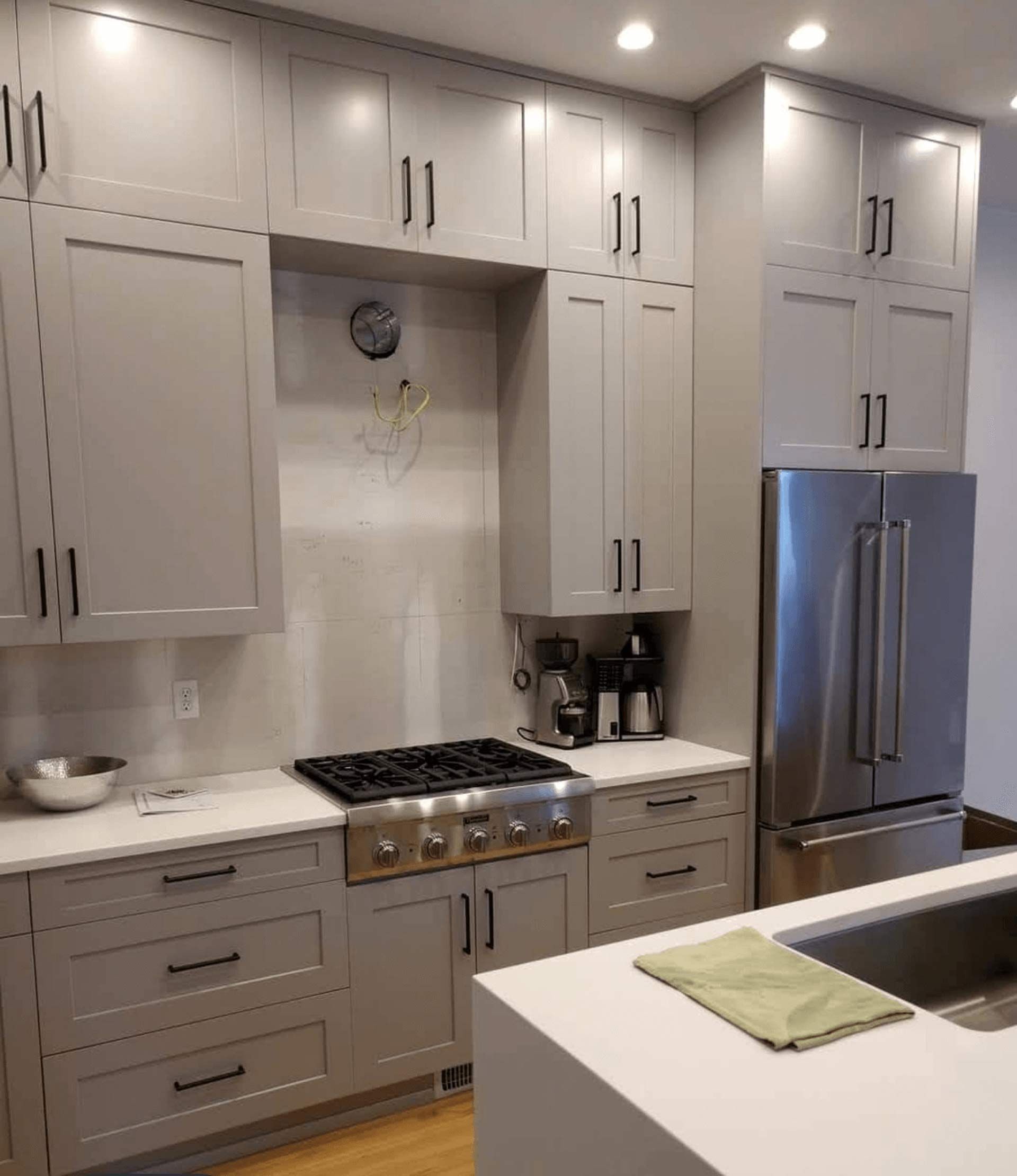 A kitchen with stainless steel appliances and gray cabinets