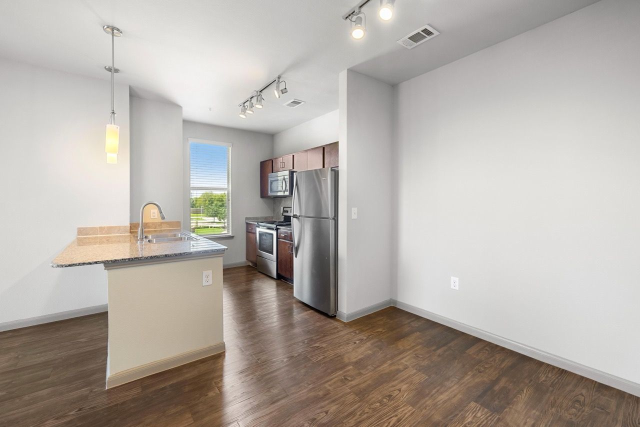 Open-concept kitchen with island, sink, and stainless-steel appliances.