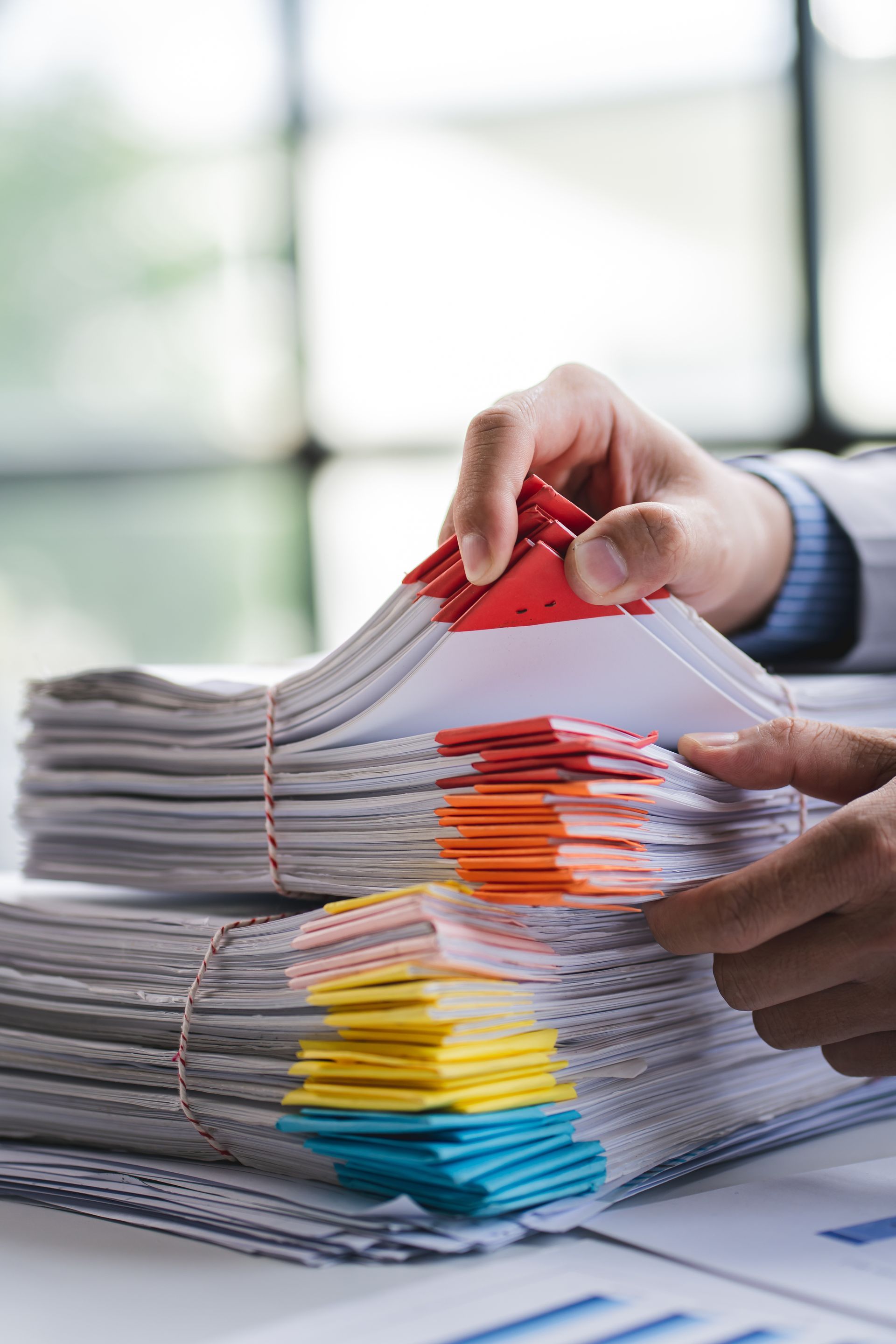 An elderly couple is sitting on a couch looking at a laptop computer.