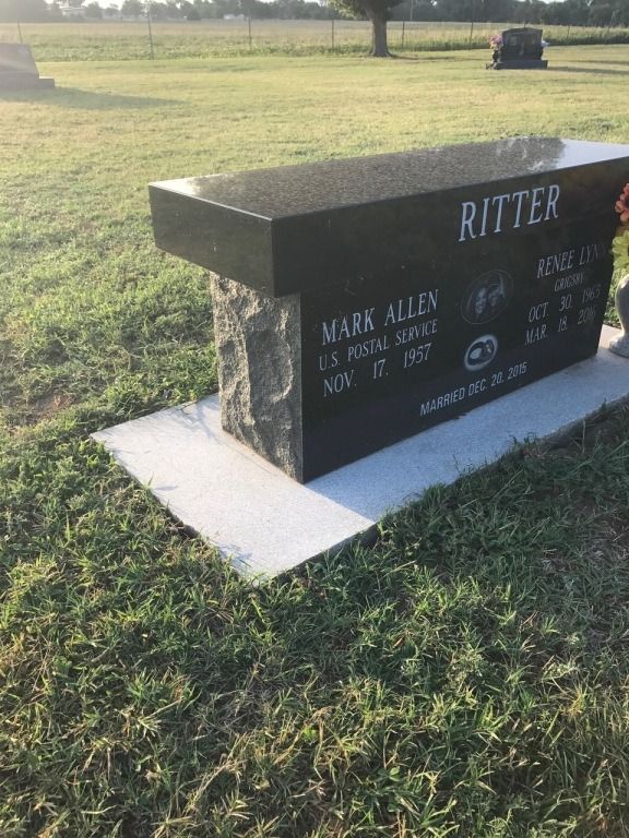A black bench in a cemetery with the name ritter on it