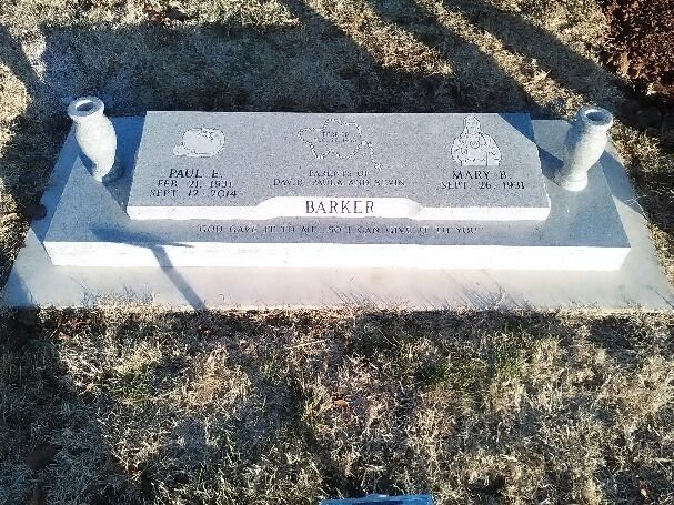 A grave with two vases on top of it in a cemetery.